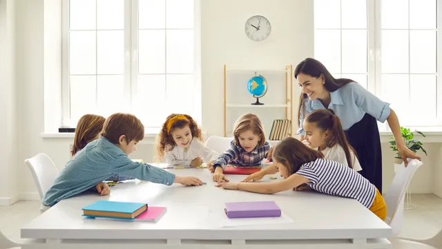 profesora de educación primaria trabaja en una actividad en clase con sus estudiantes