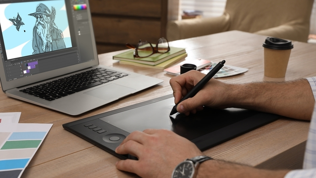 animador trabajando con tableta gr&aacute;fica y ordenador port&aacute;til