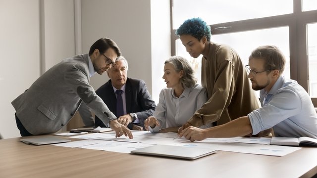 directivos, jefes de equipo y principales partes interesadas están reunidos en una sala de conferencias y hablan sobre la planificación estratégica de la empresa