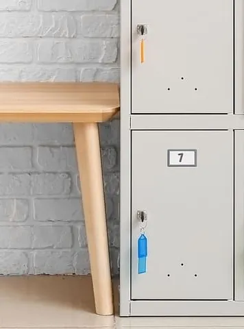 taquillas del gimnasio de un centro educativo junto a banco de madera
