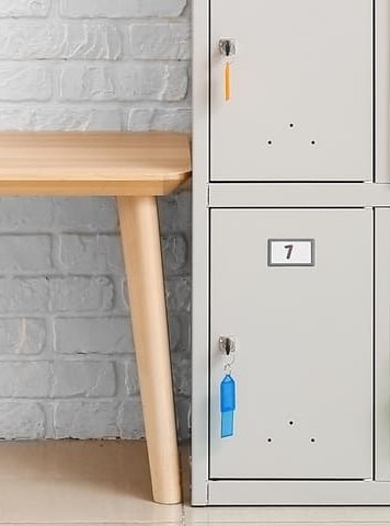 taquillas del gimnasio de un centro educativo junto a banco de madera