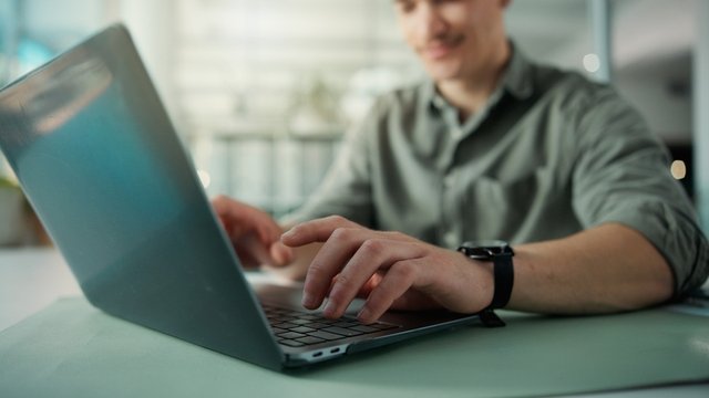 manos de un hombre que investiga con su ordenador portátil una estrategia de marketing en redes sociales