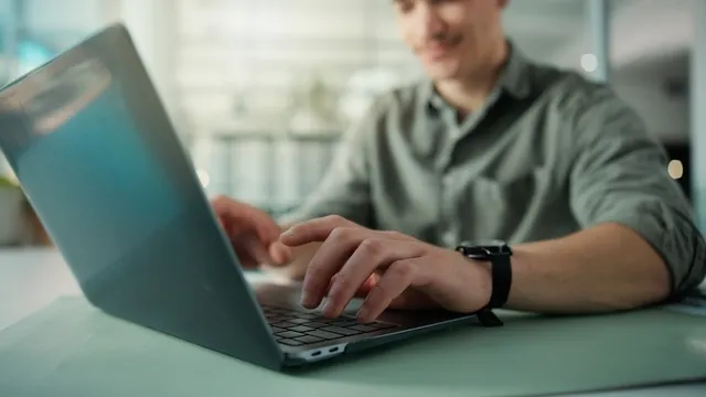 manos de un hombre que investiga con su ordenador portátil una estrategia de marketing en redes sociales
