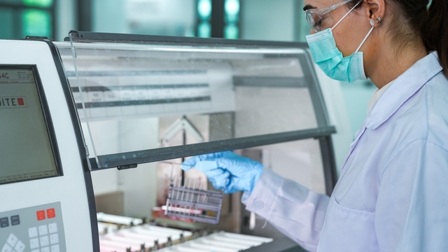 Experta femenina que maneja el flujo de trabajo de tinci&oacute;n qu&iacute;mica con tecnolog&iacute;a moderna en las instalaciones del laboratorio de ciencias