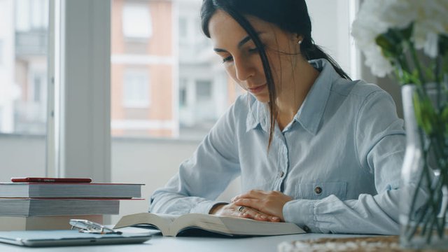 Chica joven leyendo un libro, preparándose para un examen