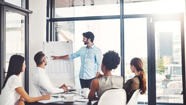 directores de una empresa reunidos en una sala de juntas para hablar de la estrategia de negocios