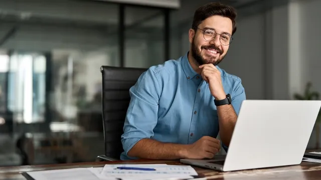 retrato de un empresario feliz sentado frente a su ordenador portátil