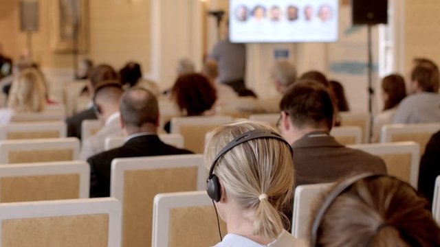 personas usando auriculares durante una conferencia internacional