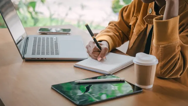A young student takes notes using a pen