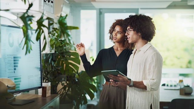 Hombre, mujer y tableta por monitor en el inicio con revisi&oacute;n, Estad&iacute;sticas o lluvia de ideas con gr&aacute;ficos para la sostenibilidad. Personas, colaboraci&oacute;n y pantalla t&aacute;ctil sobre App, sostenibilidad y consultor&iacute;a clim&aacute;tica