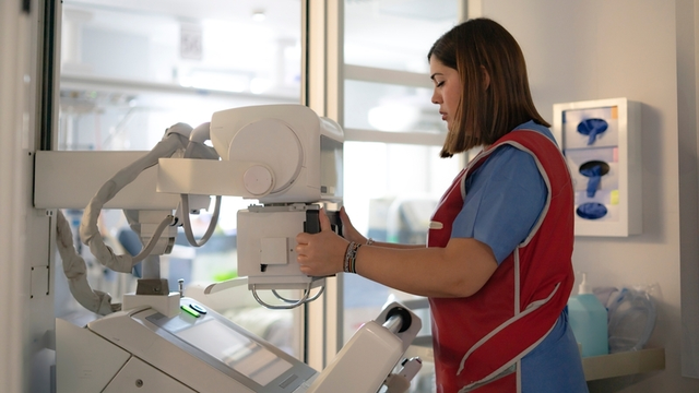 TSID ajusta una máquina de radiografías en la habitación de un hospital