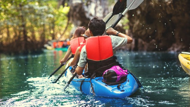 dos personas remando un kayak en un río