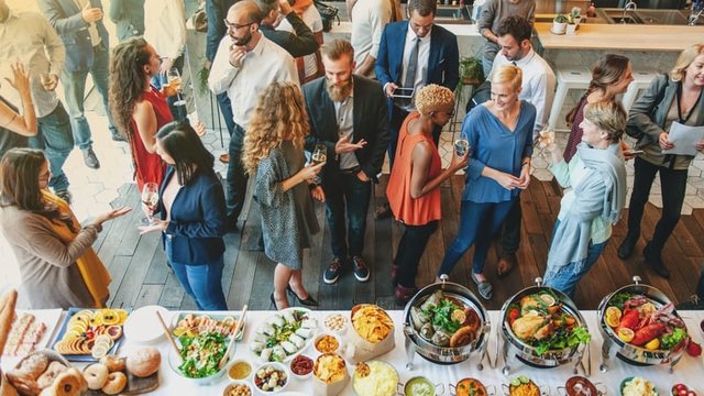 hombres y mujeres de negocios disfrutan de un buffet en el salón de un hotel