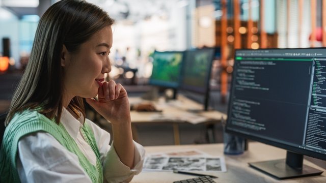 mujer programadora de juegos en ordenador de sobremesa